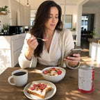 WomanenjoyinghealthybreakfastwithSNAFREstrawberryslicesontoastandyogurt