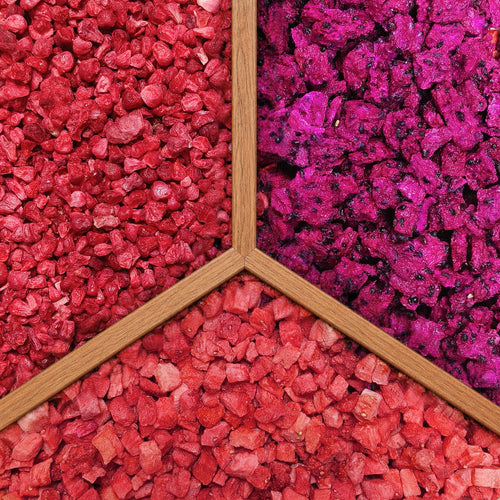 Close-up texture of 3 freeze-dried fruit crumbles: strawberry, dragon fruit, and raspberry