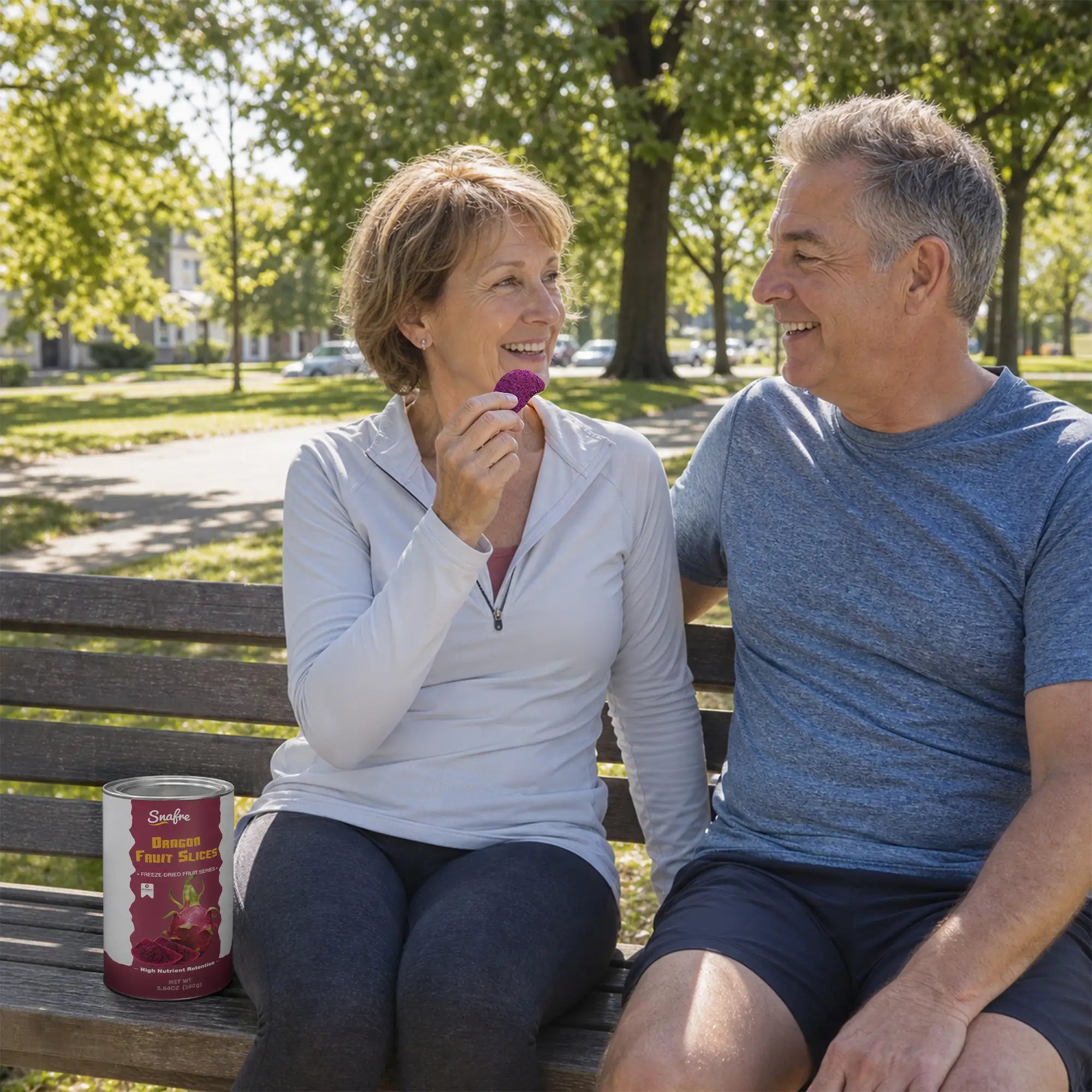 Senior couple eating healthy snacks outdoors with SNAFRE red dragon fruit canister