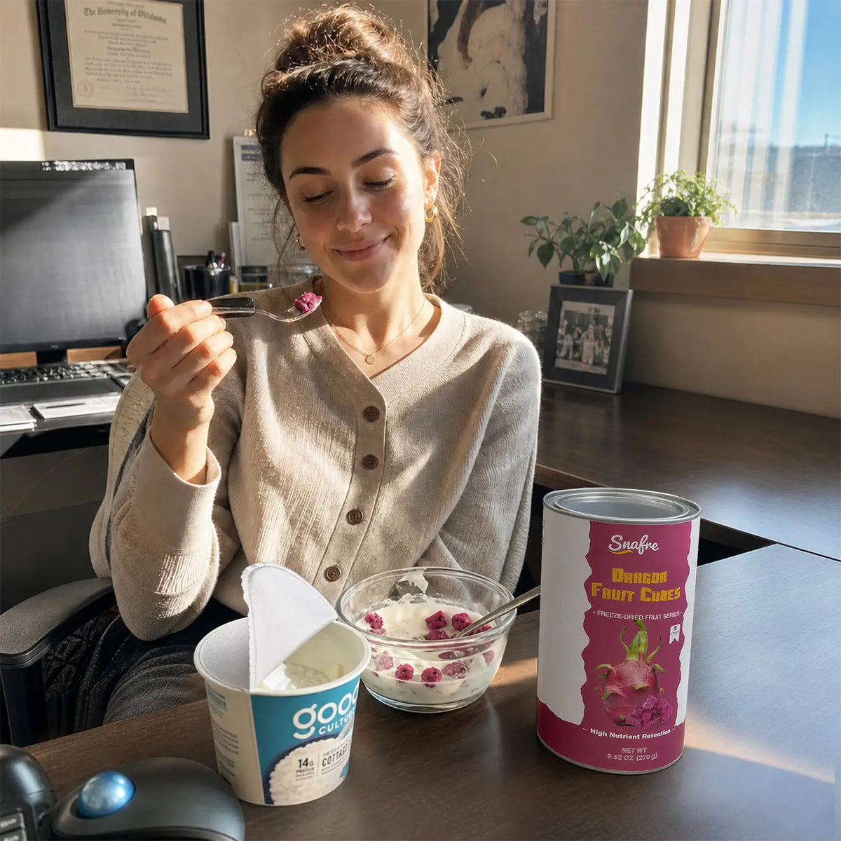 Woman enjoying healthy yogurt lunch topped with SNAFRE freeze-dried fruit crumbles