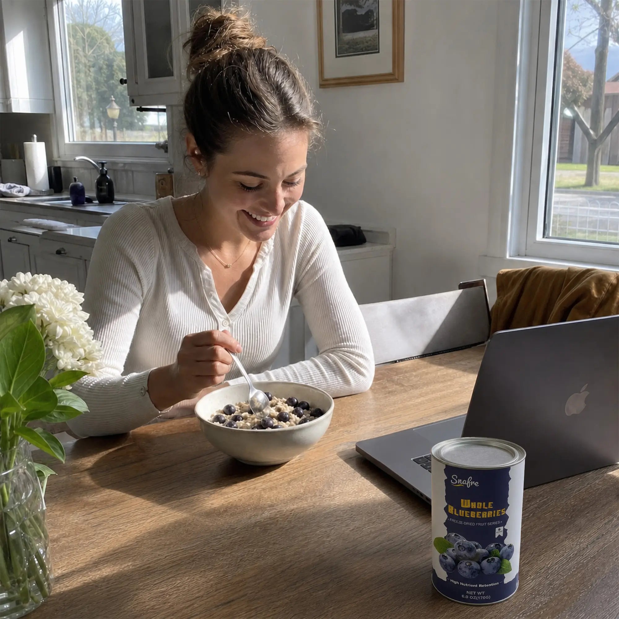 WomaneatinghealthyyogurtbowlwithSNAFREblueberriesathome